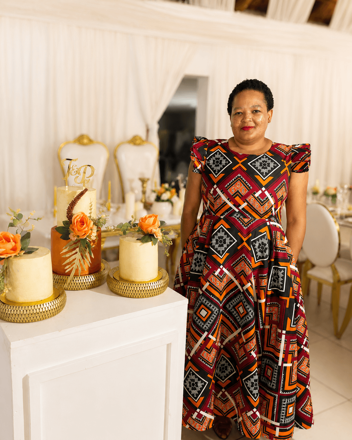 Matshidiso (Tshidi), founder of Glory Treats, standing beside a three-tier wedding cake she created