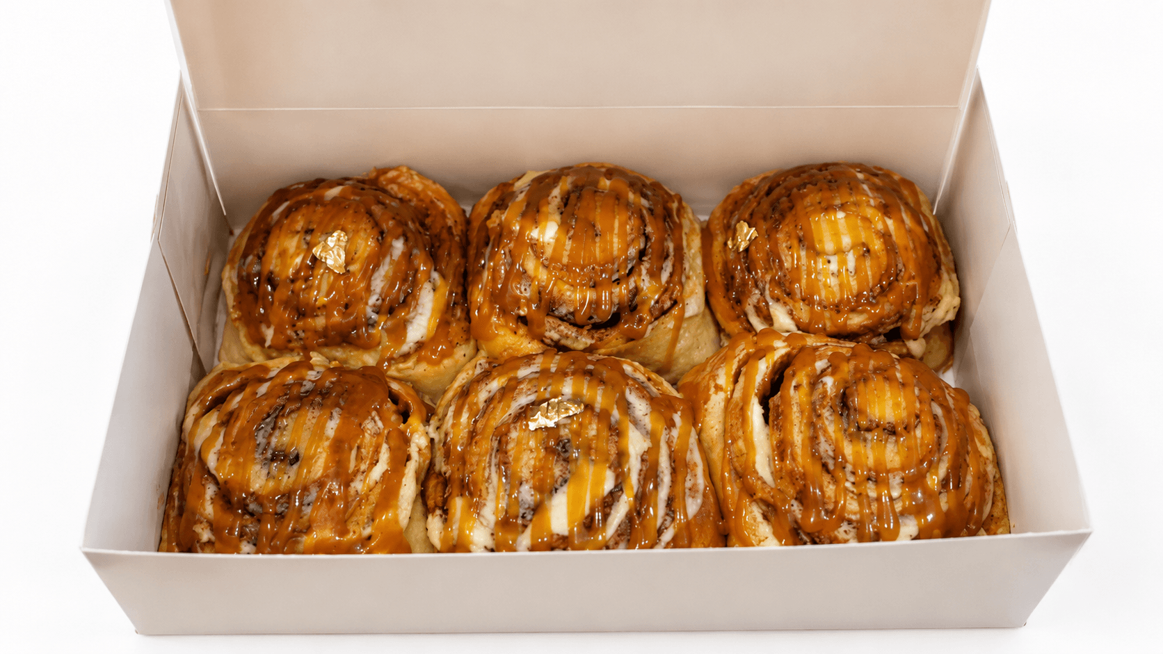 Caramel cinnamon rolls finished with gold leaf by Glory Treats